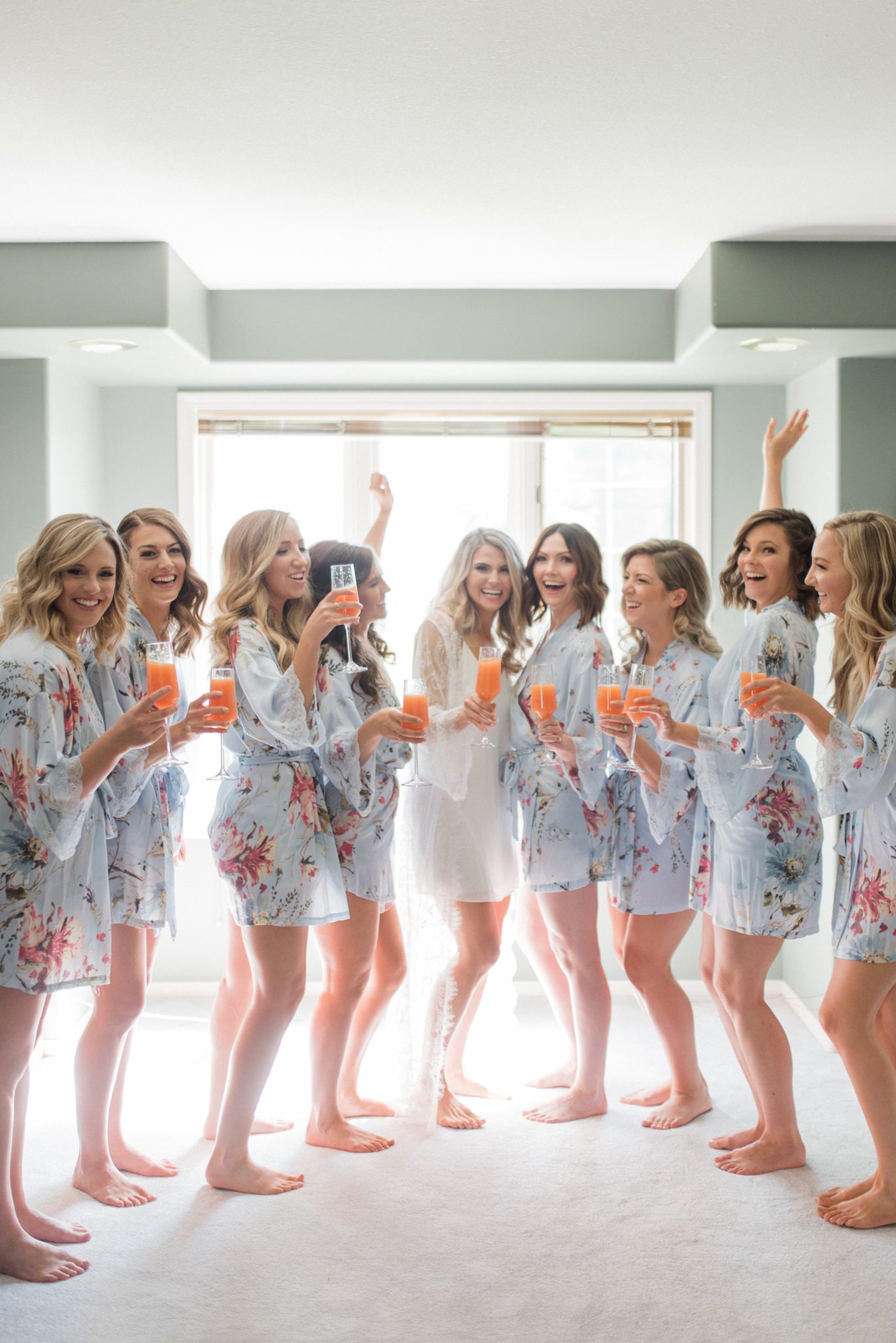 Bridesmaids in pale blue and floral robes on a wedding day morning