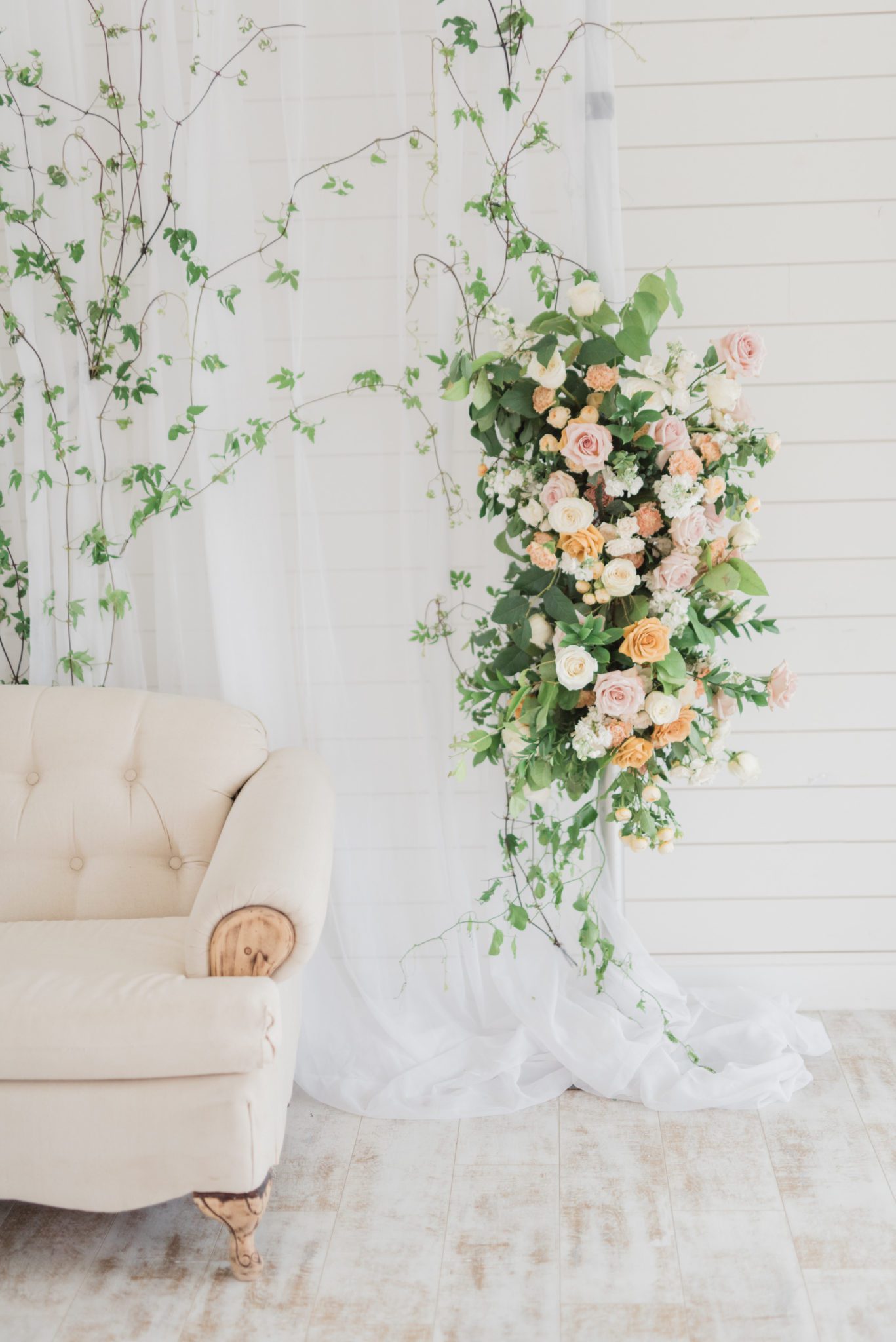 Romantic and minimal wedding decor with soft florals and a loveseat