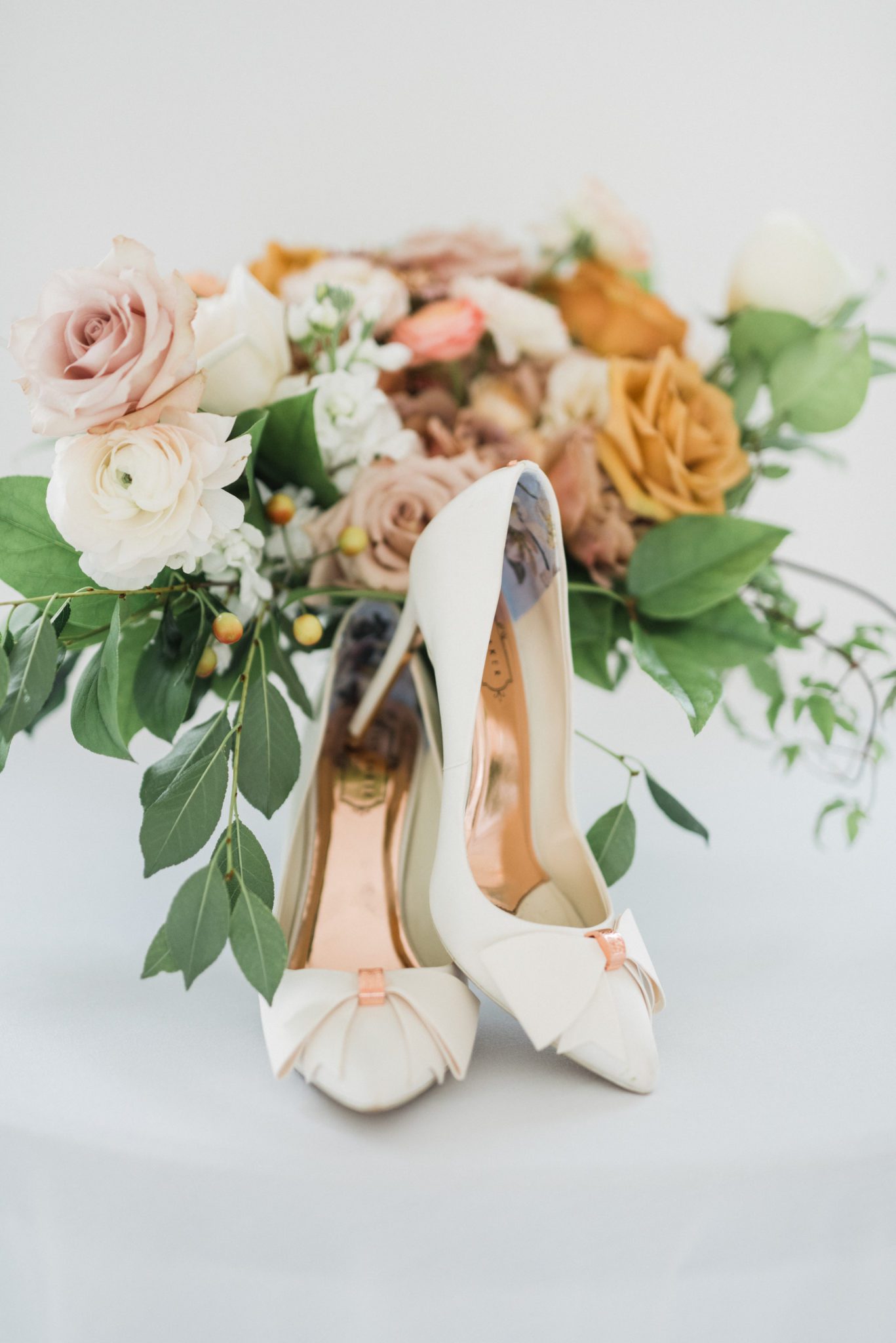 White bridal pumps with rose gold accents