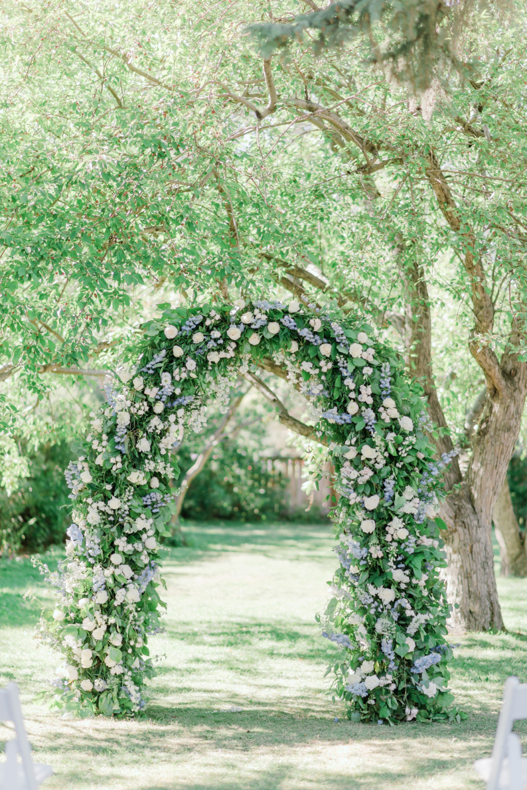Showstopping white and green floral arch for a gardensque wedding