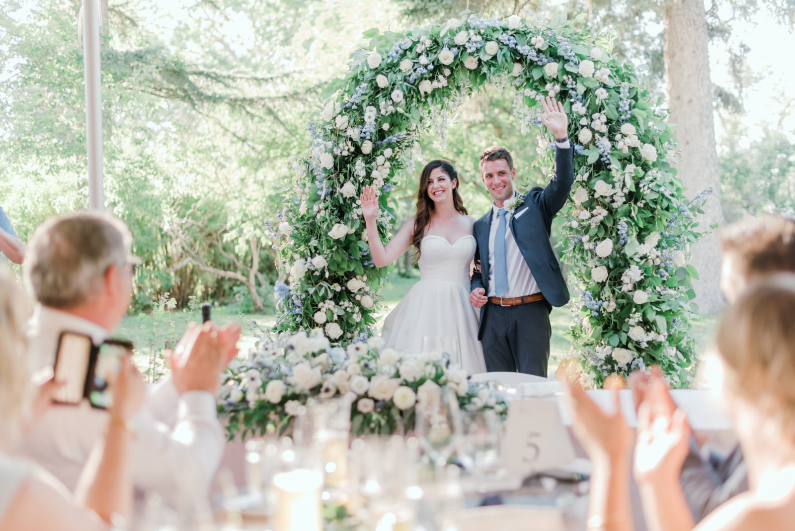 Timeless fine art summer wedding reception decor with a show-stopping white and blue floral arch