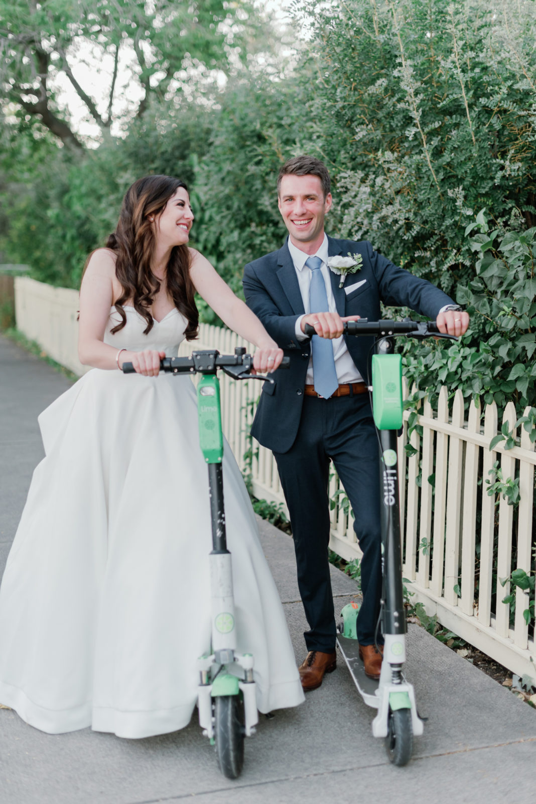 Bride and groom ride electric scooters on their wedding day