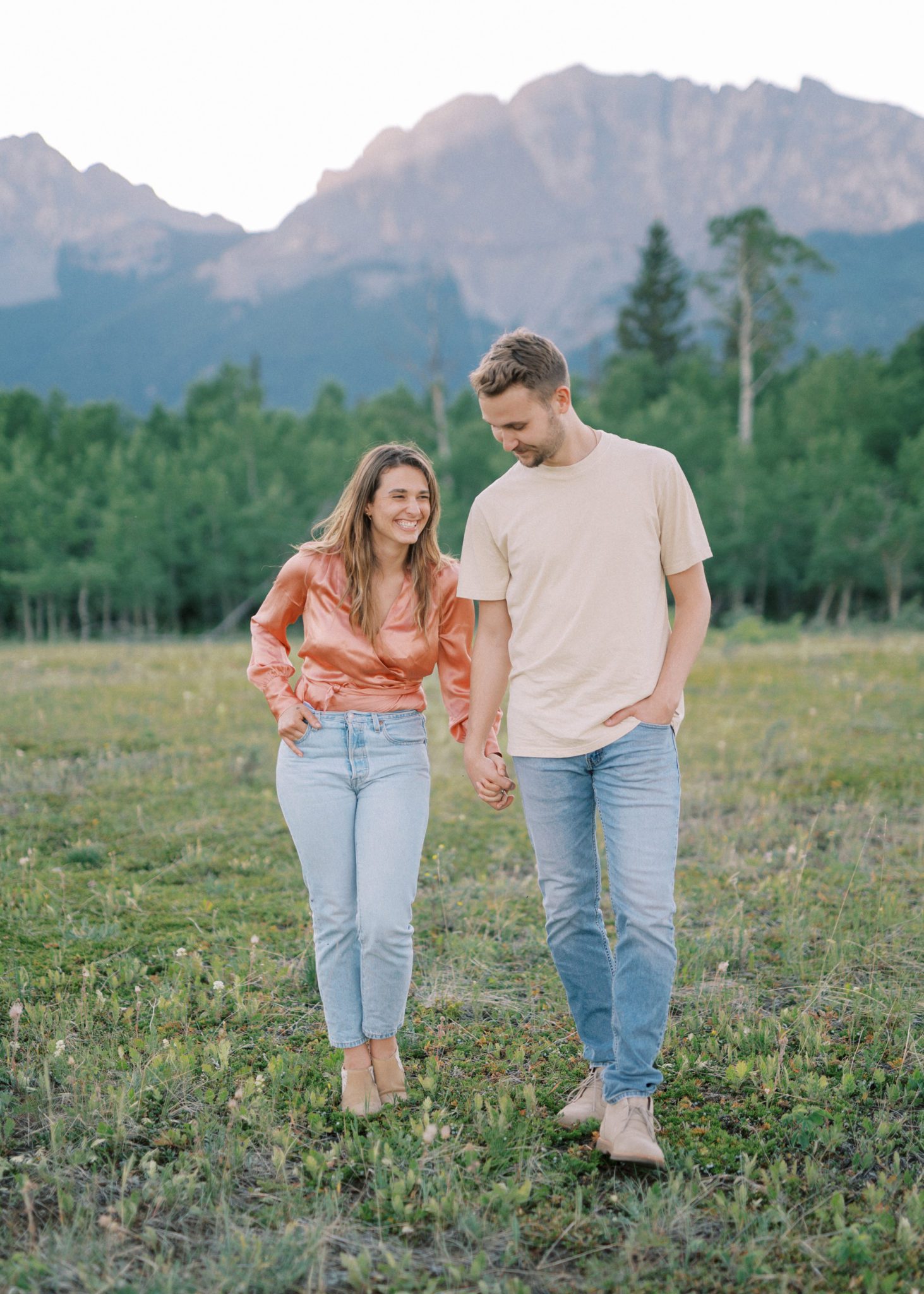 Couple walks hand in hand for their mountain photography session