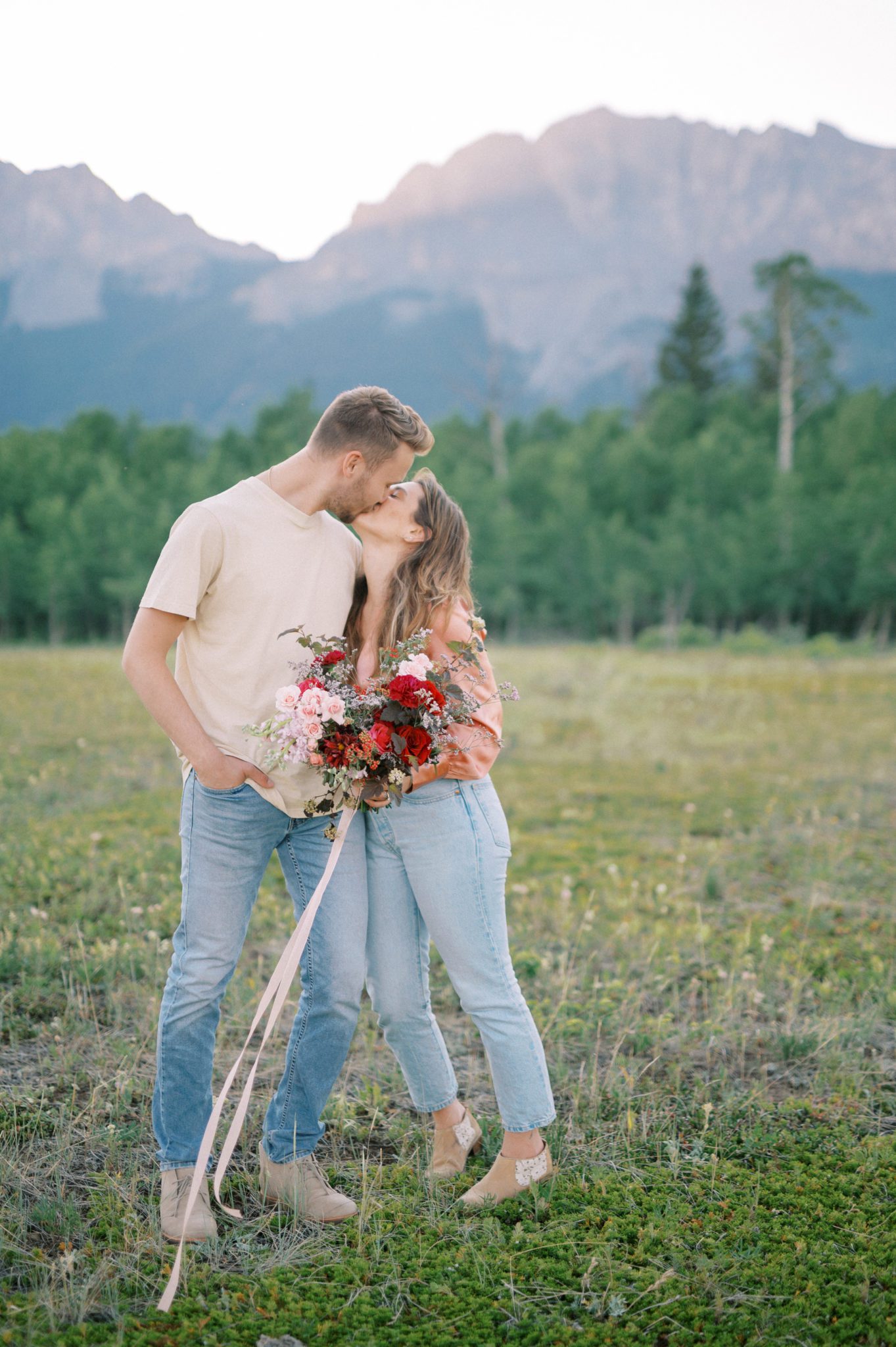 Fresh and fun couples session in the mountains with a vibrant floral bouquet