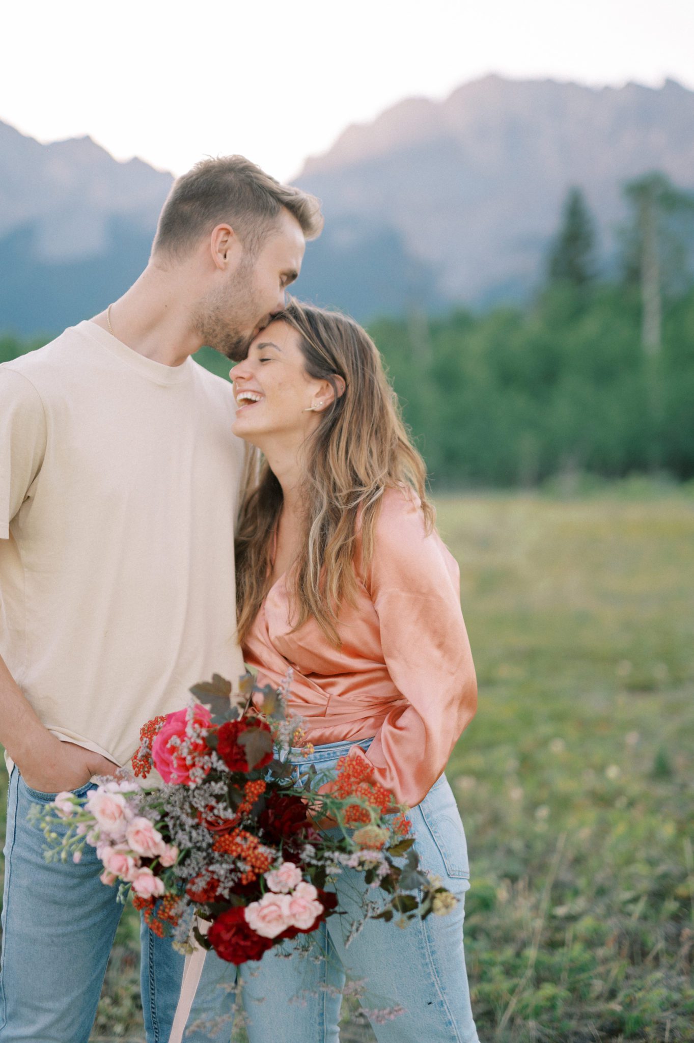 Couples session in the mountains featuring a vibrant bouquet with pink and berry hues
