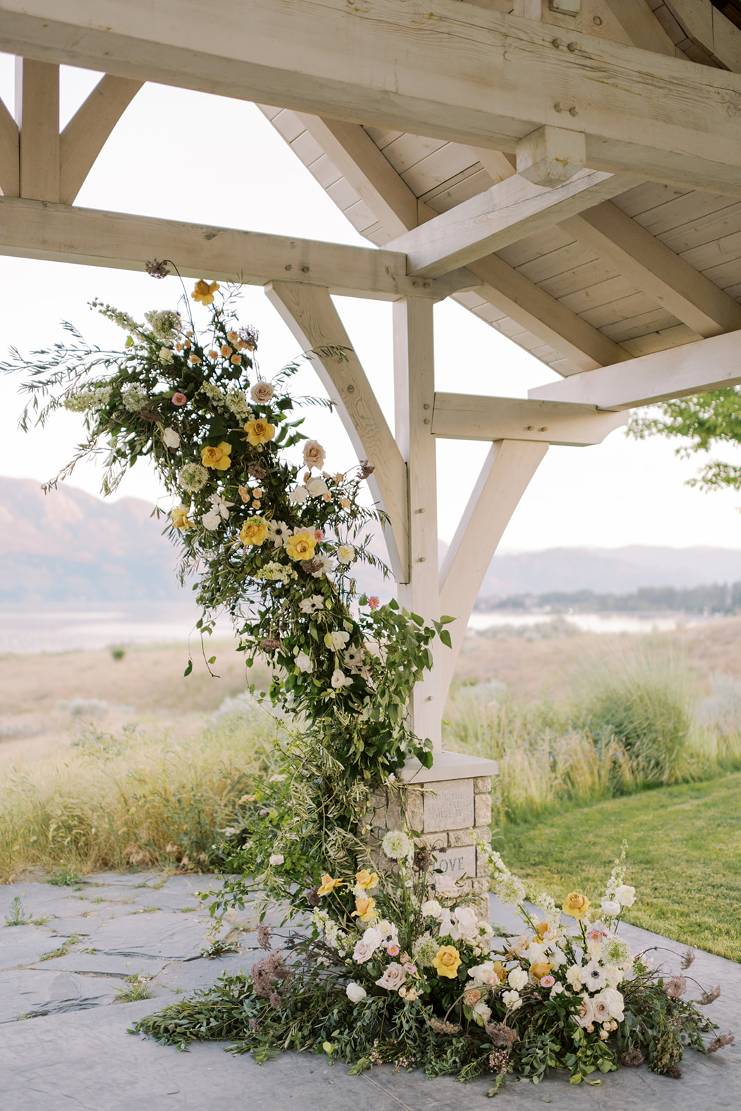 Floral ceremony arch for an outdoor summer wedding at Sanctuary Gardens