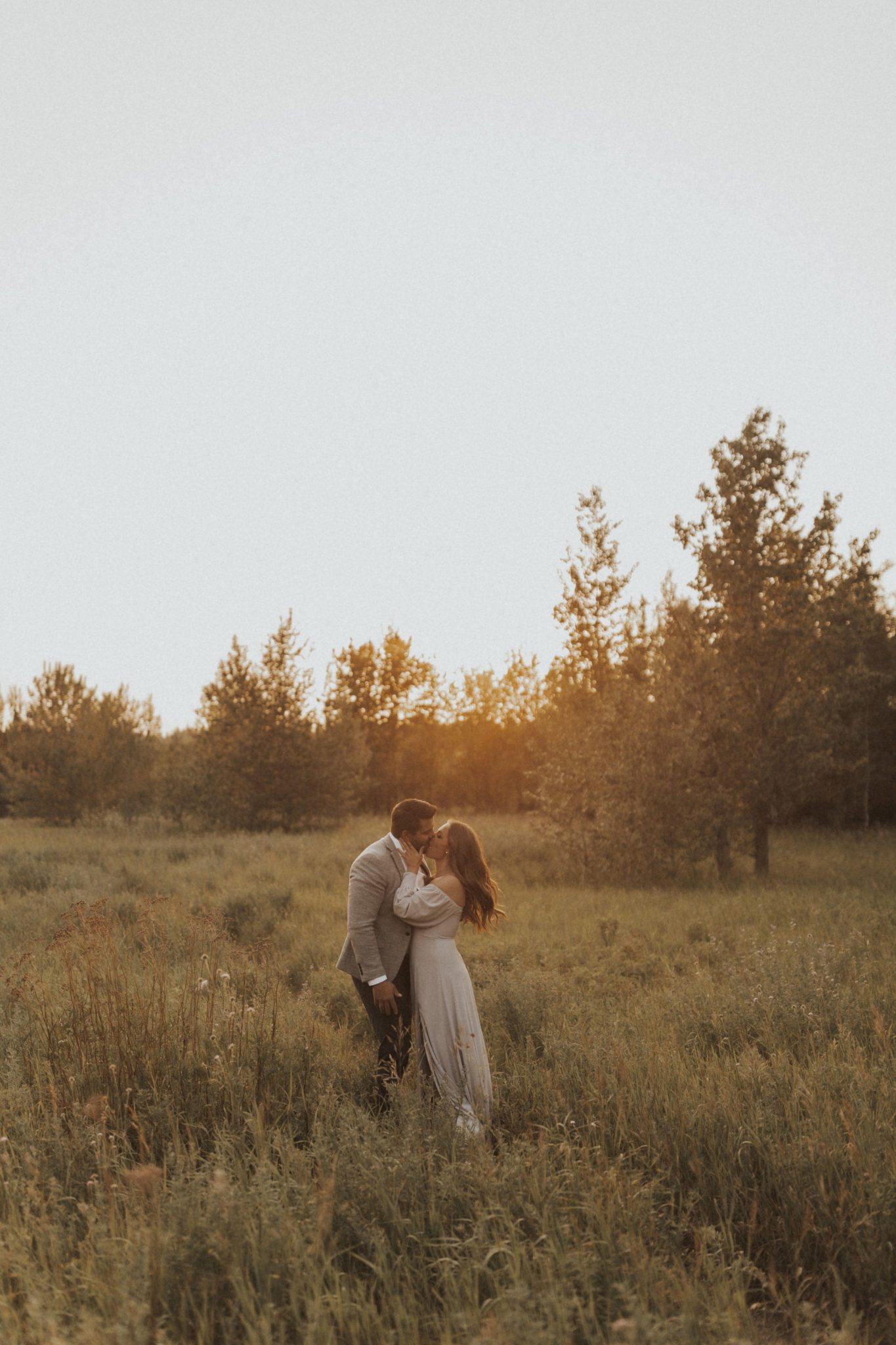 Dreamy and romantic engagement session in a sunset field