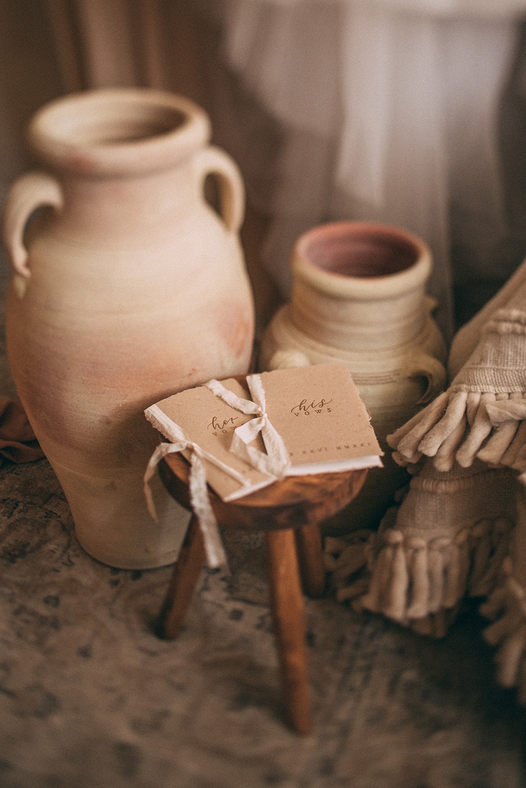 Boho wedding details with clay pots and neutral hue vow booklets