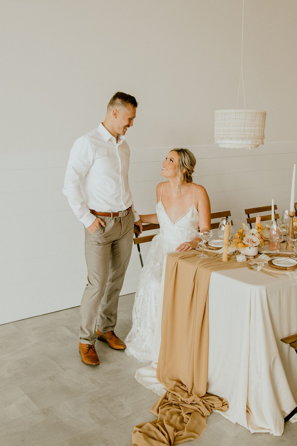 Bride and groom seated at boho styled wedding reception table at Tin Roof Events Centre