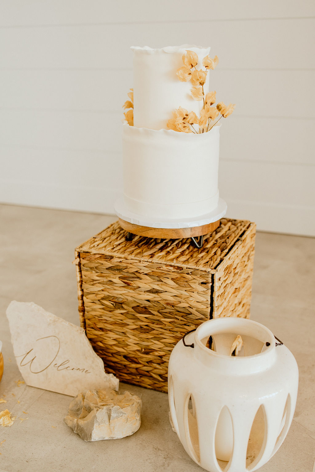 Two tiered ruffled wedding cake with dried florals