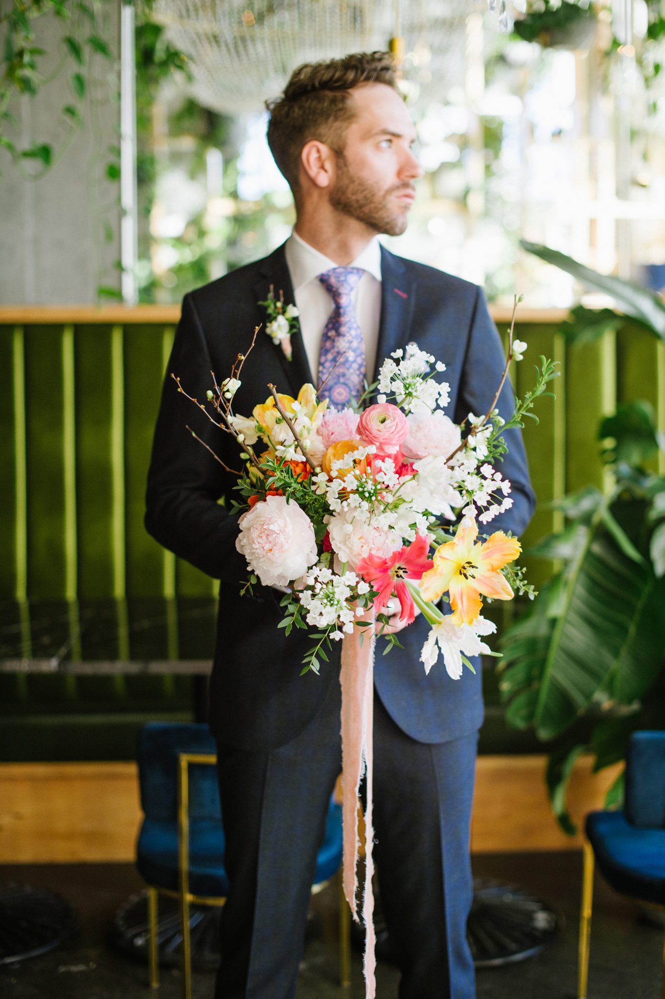Groom portrait holding bright spring bouquet