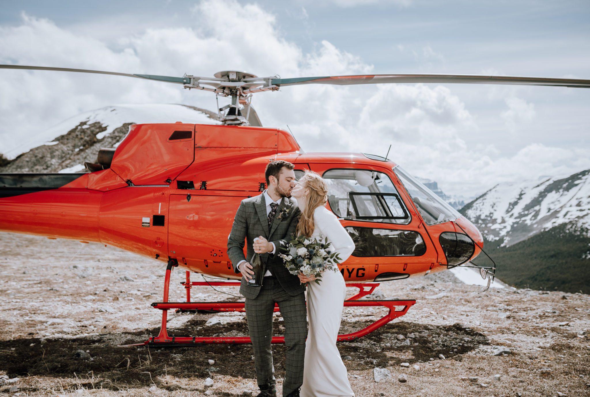 Adventure elopement with mountaintop champagne toast and helicopter tour