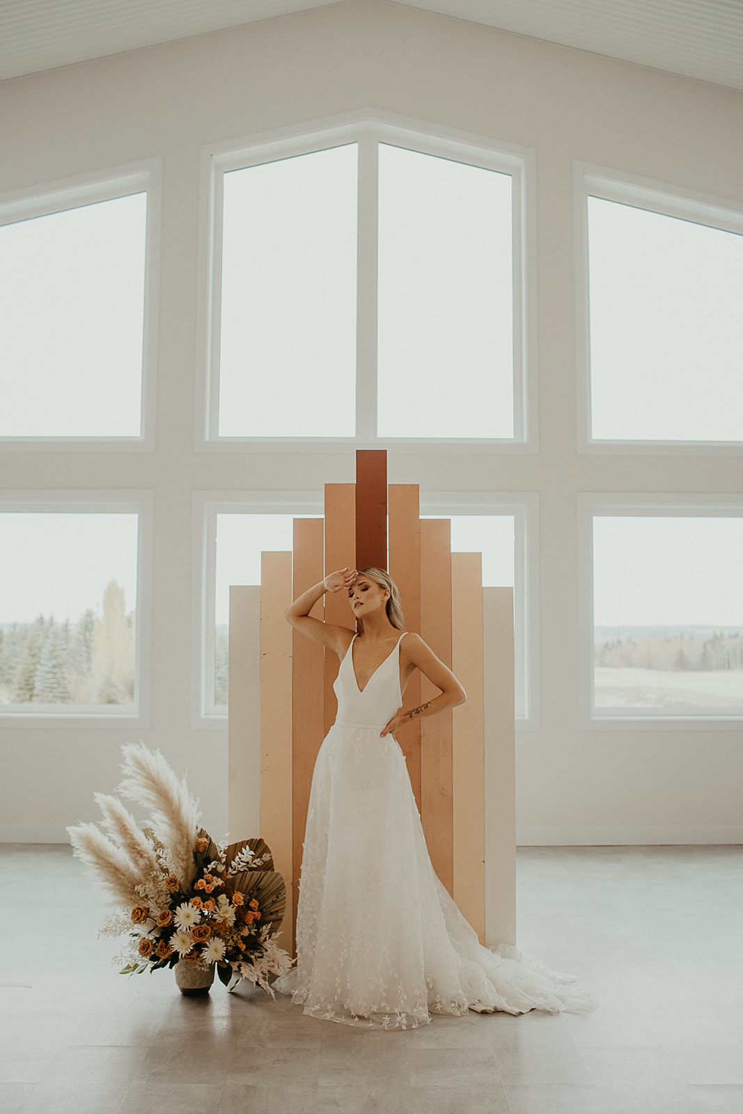 Pampas grass and unique stylized wedding backdrop inspiration, floor-length contemporary boho bridal look 