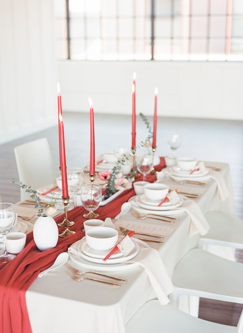 Modern Wedding Table Design in Vancouver BC, with Asian inspired place settings, taper candles in a bold red accent, and modern decor elements.