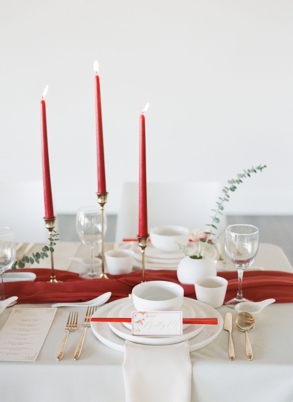 Modern Wedding Table Design in Vancouver BC, with Asian inspired place settings, taper candles in a bold red accent, and modern decor elements.
