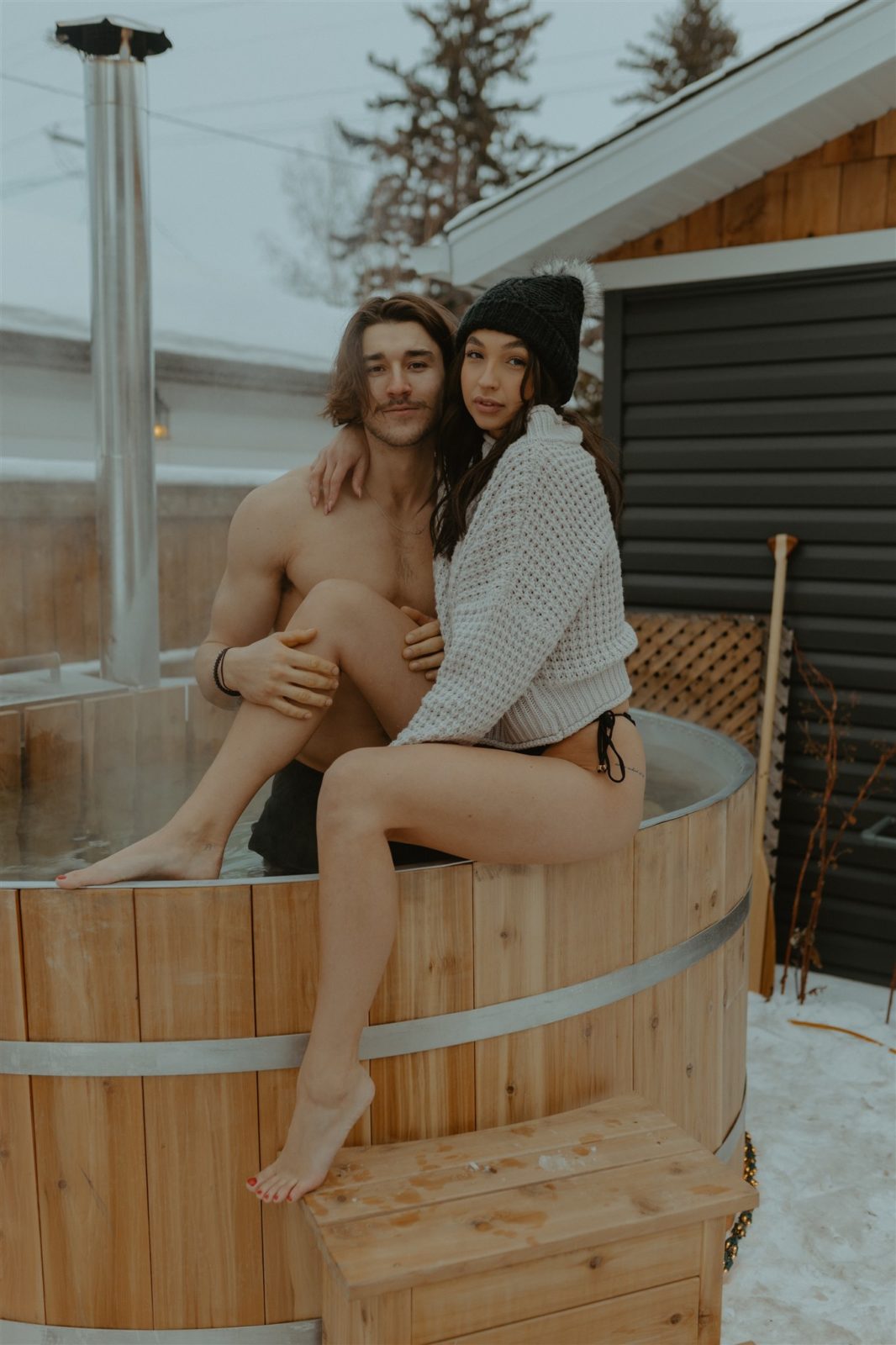 Couple photo session in hot tub during Alberta winter, ways to stay warm during your engagement session