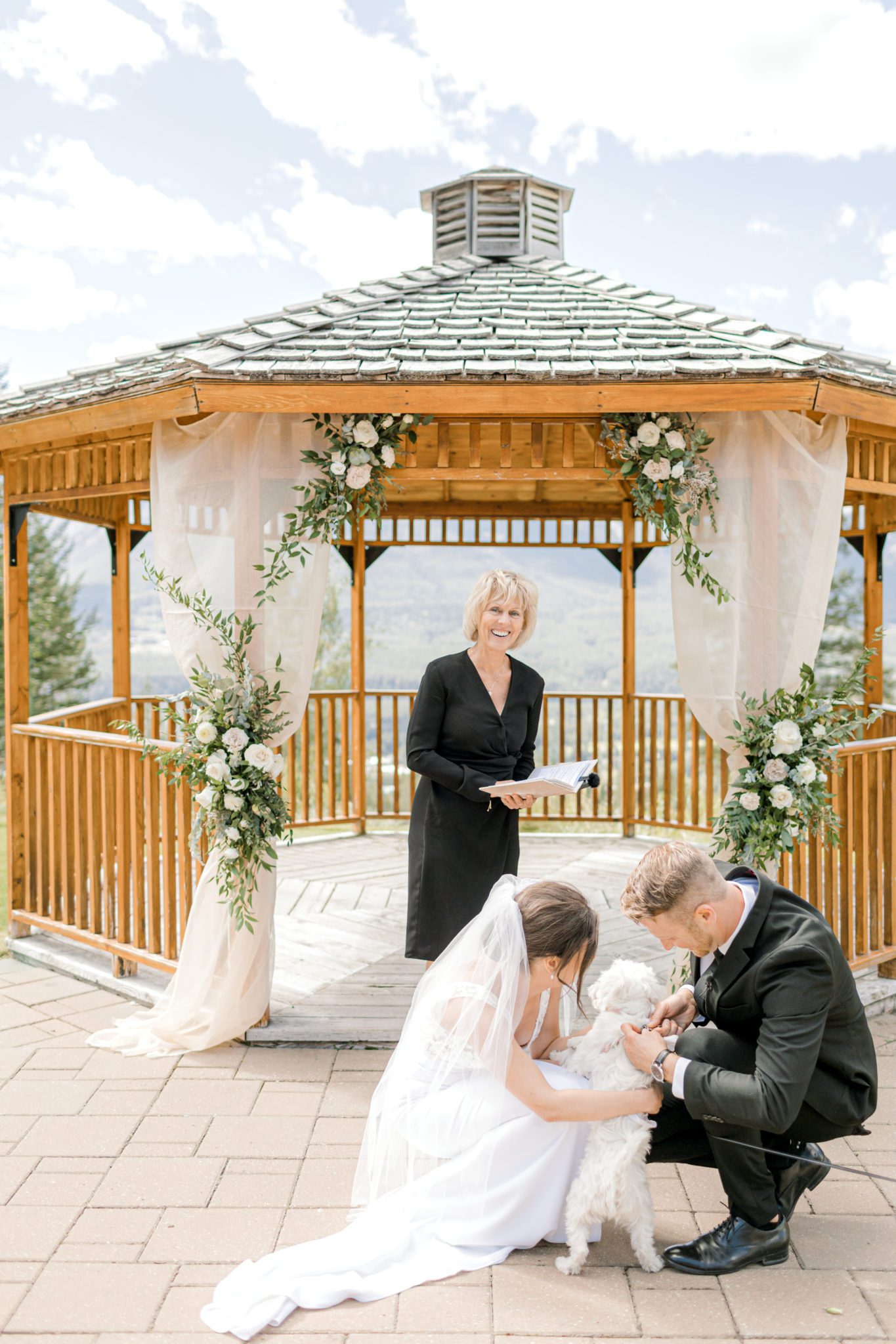 Intimate outdoor gazebo wedding in Canmore, Alberta. Bride and groom involving dog in ceremony.