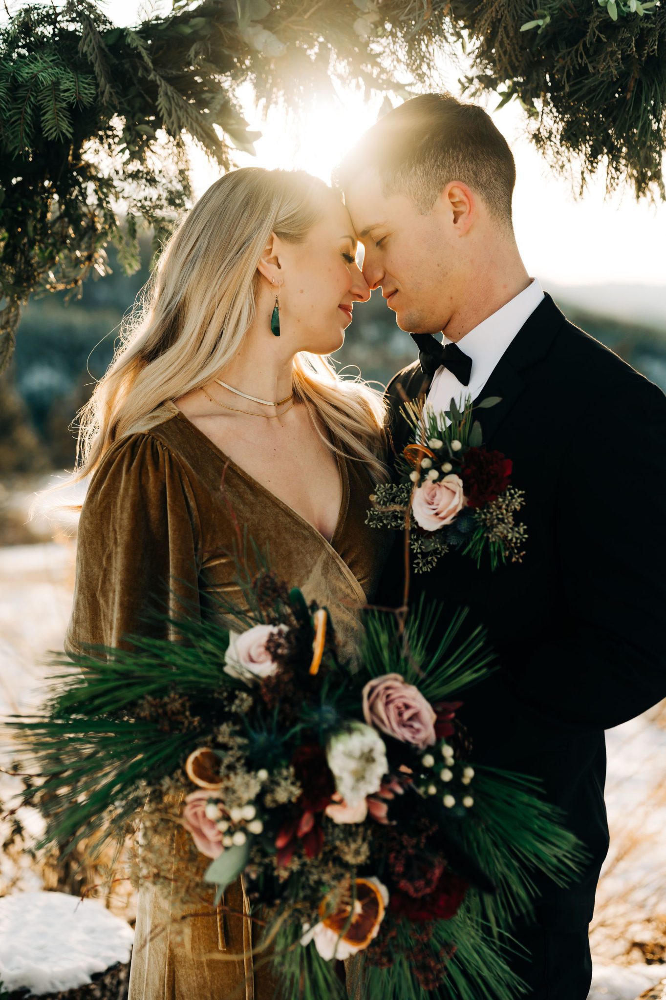 Pine and candied orange bouquet at this golden hour elopement, winter outdoor wedding inspiration