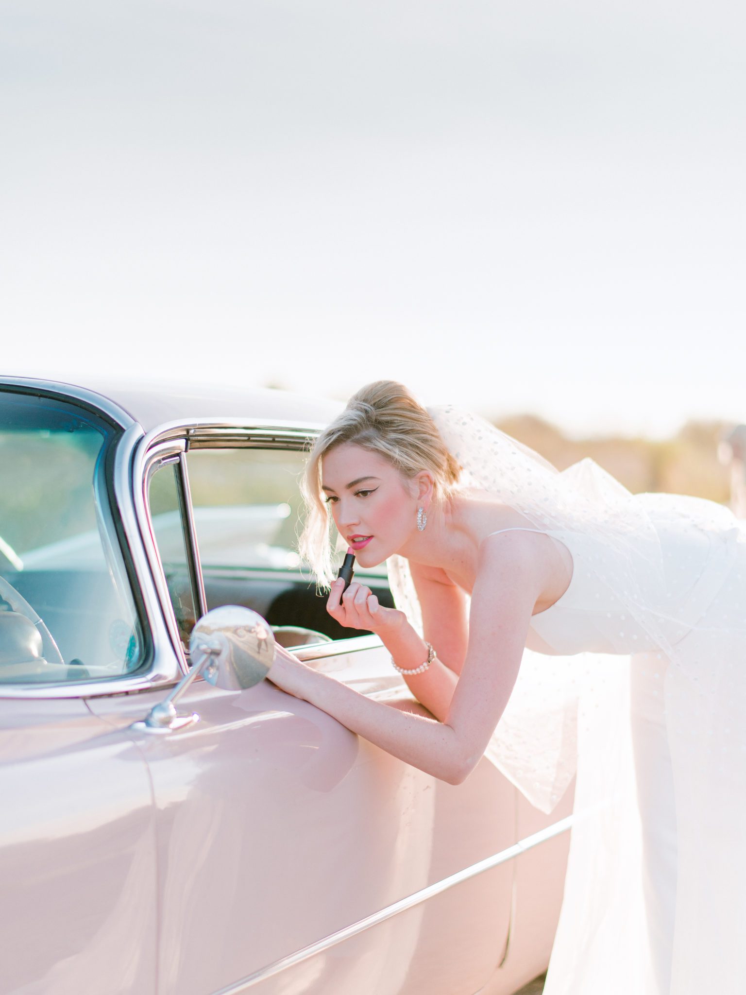 Makeup touchup for this retro bride featuring a pink Cadillac, retro inspired styled shoot in BC