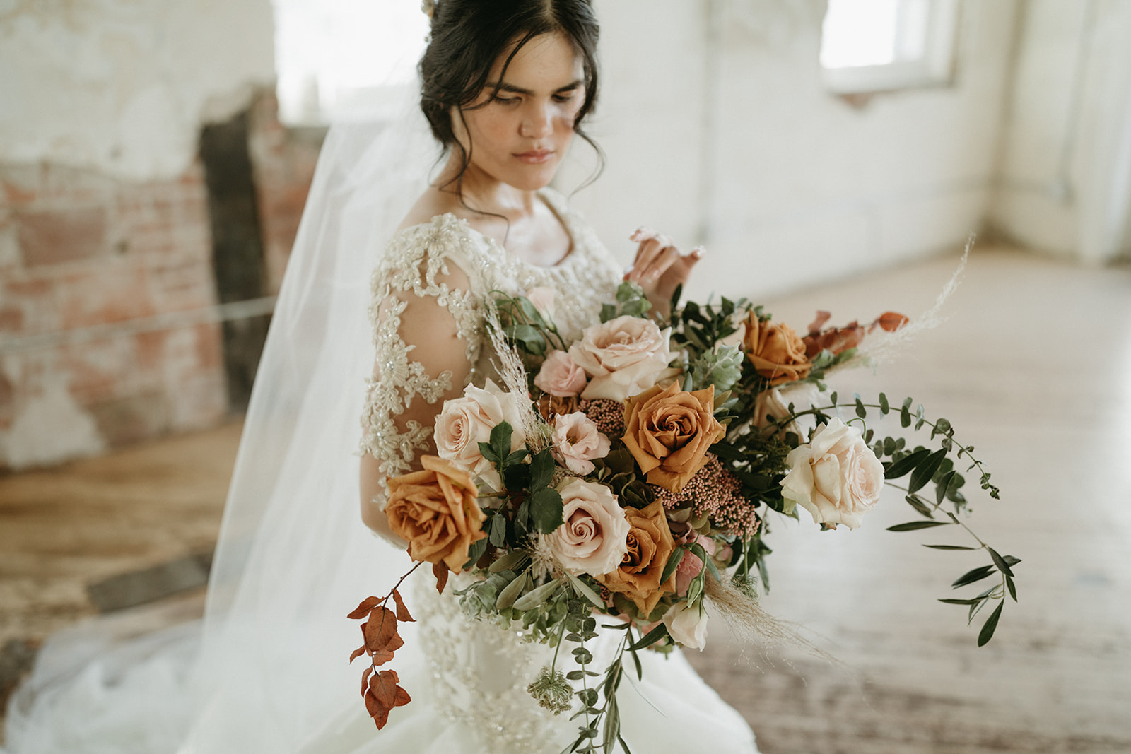 Bride with neutral toned bouqet with earthy green and rust florals