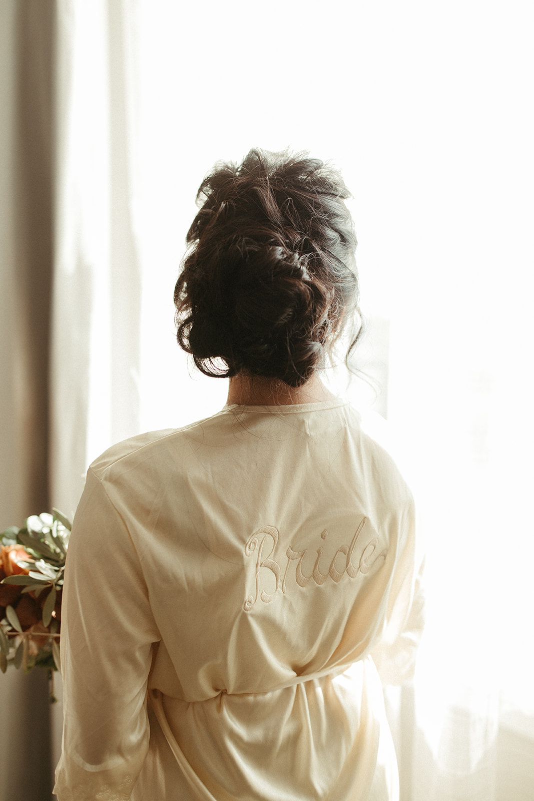 Bride gets ready for wedding in silk robe, bridal hair inspiration