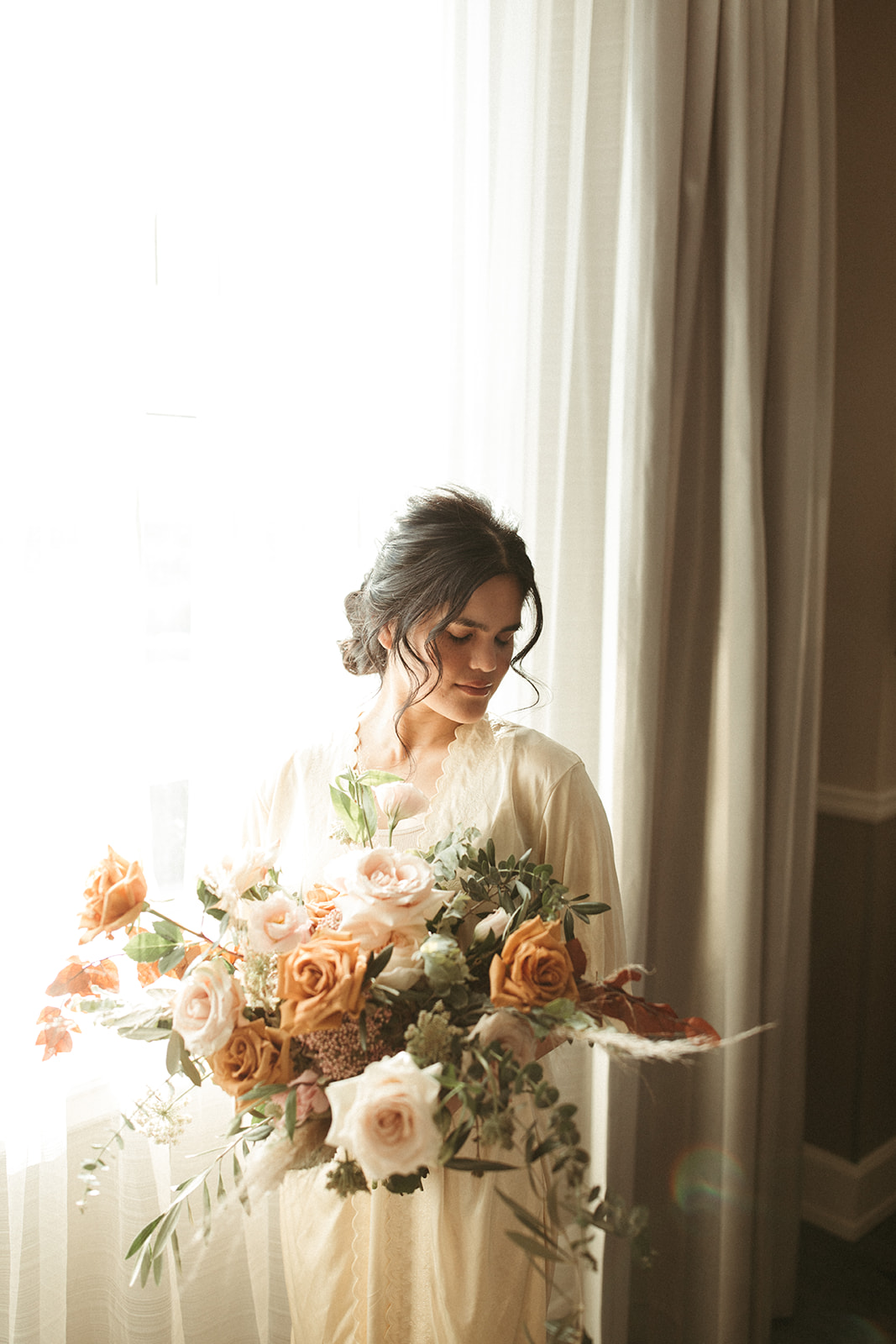 Bride poses with neutral toned floral bouquet