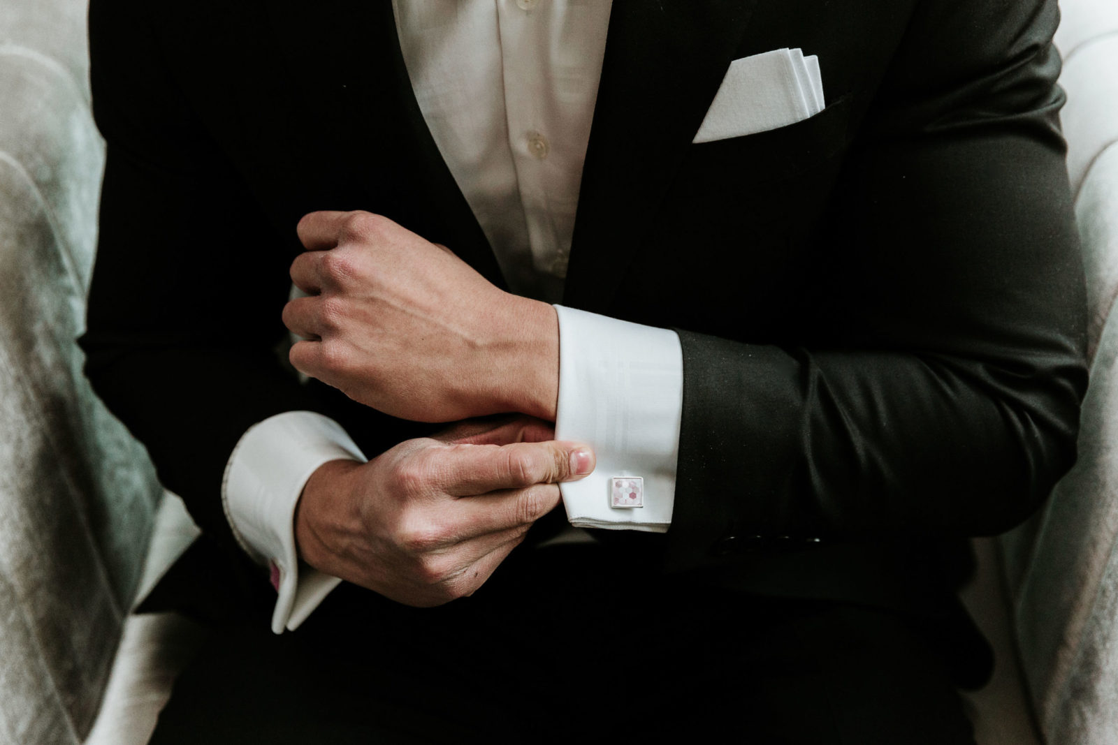 Modern and Glamorous Wedding Celebration Inspiration With A Pop of Pink | groom black tux fixing cufflinks