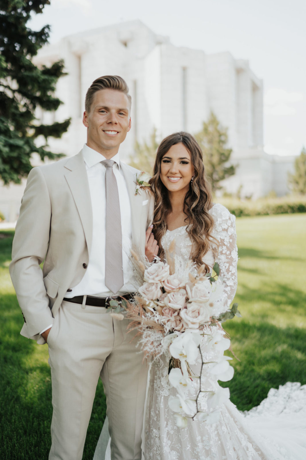 Bride and groom stand outside Cardston temple for portraits