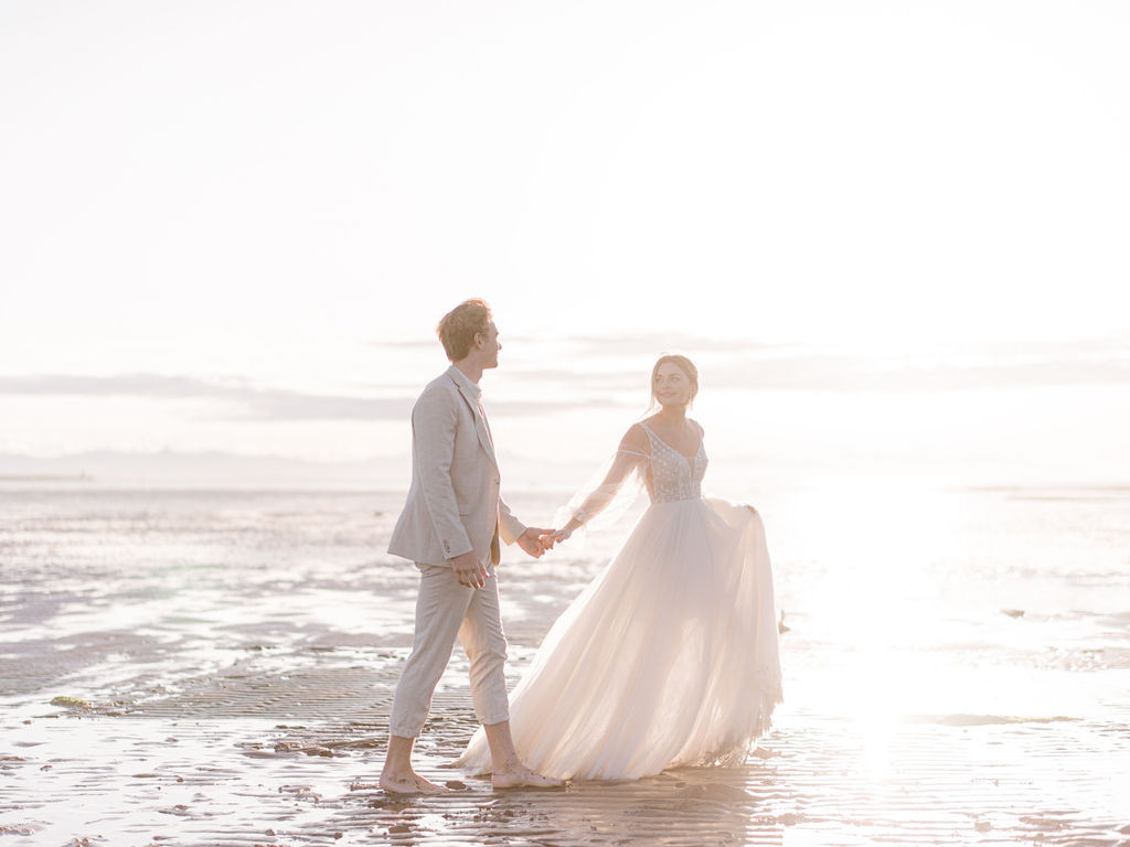 Romantic wedding portraits on the beach in Vancouver, British Columbia; Fine art wedding inspiration with a flowy beach wedding dress with poofy sheer sleeves, beach wedding attire, beach bridal style, bride hair and makeup ideas, low bridal ponytail for an intimate wedding