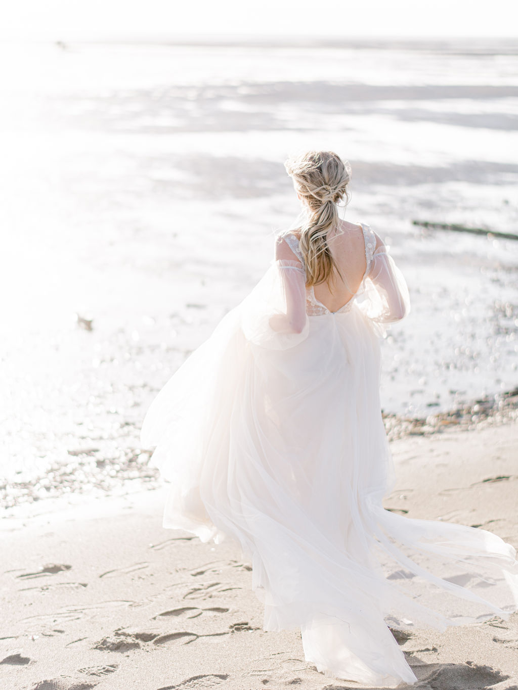 Romantic wedding portraits on the beach in Vancouver, British Columbia; Fine art wedding inspiration with a flowy beach wedding dress with poofy sheer sleeves, beach wedding attire, beach bridal style, bride hair and makeup ideas, low bridal ponytail for an intimate wedding