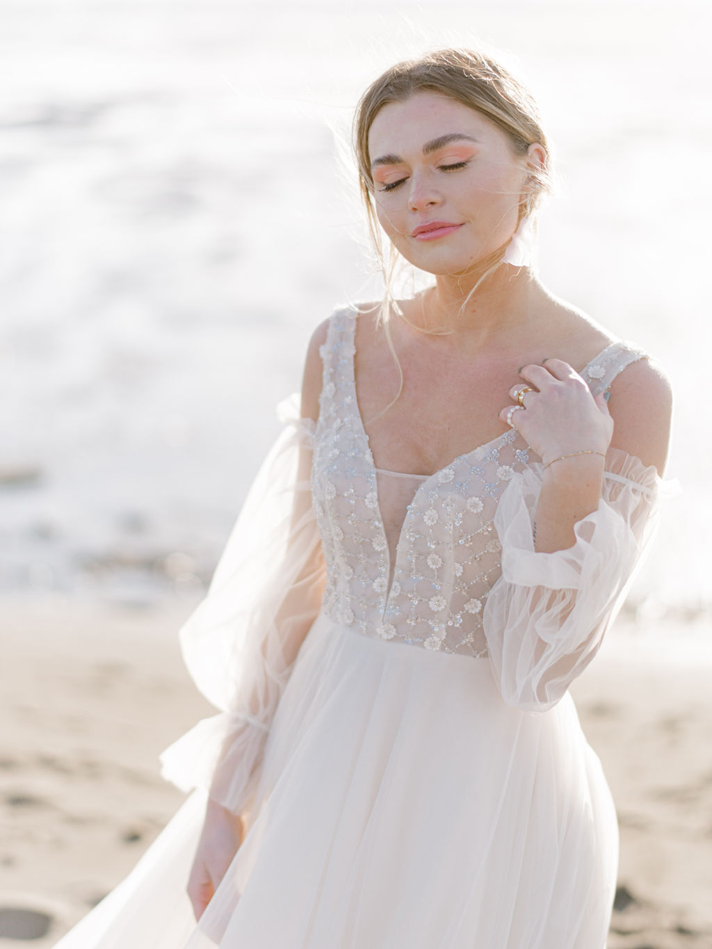 bride portrait on the beach in Vancouver, British Columbia; Fine art wedding inspiration for an intimate beach wedding; flowy beach wedding dress with poofy sheer sleeves, beach wedding attire ideas
