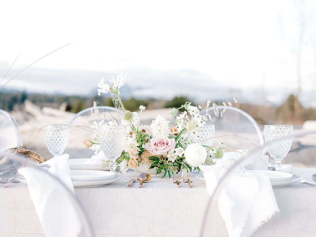 Romantic alfresco dinner along the beach for an intimate Vancouver wedding, spring and summer wedding inspiration in Canada, modern wedding tablescape design with velvet linens, ghost chair seating, and whimsical floral centerpieces in blush and sand tones