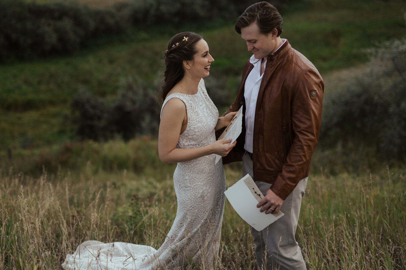 Bride and groom at their intimate vow renewal, reading their vows to each other with Alberta rural countryside as the backdrop, fall vow renewal inspiration. 