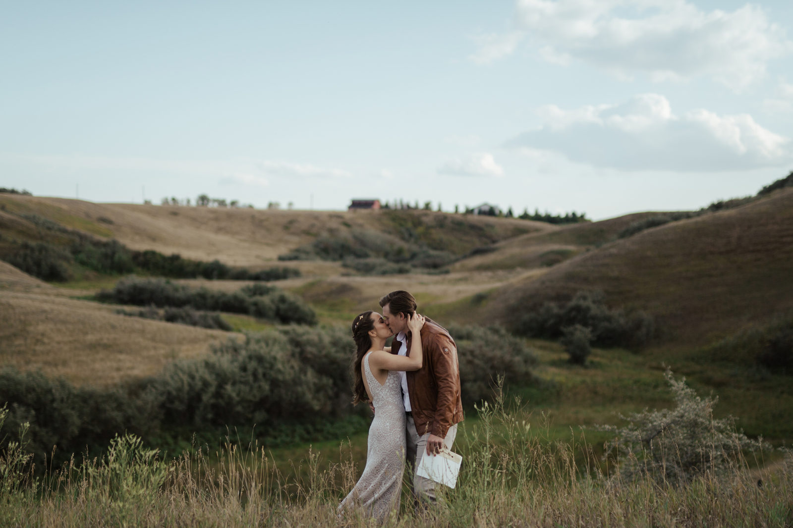 Bride and groom share a kiss after reading their vows to each other in a rural Alberta countryside, fall vow renewal inspiration. 