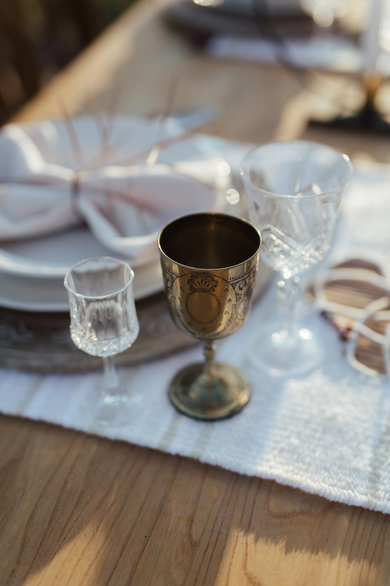 Vintage gold and clear glassware, placed on top of a wooden table, fall wedding inspiration. 