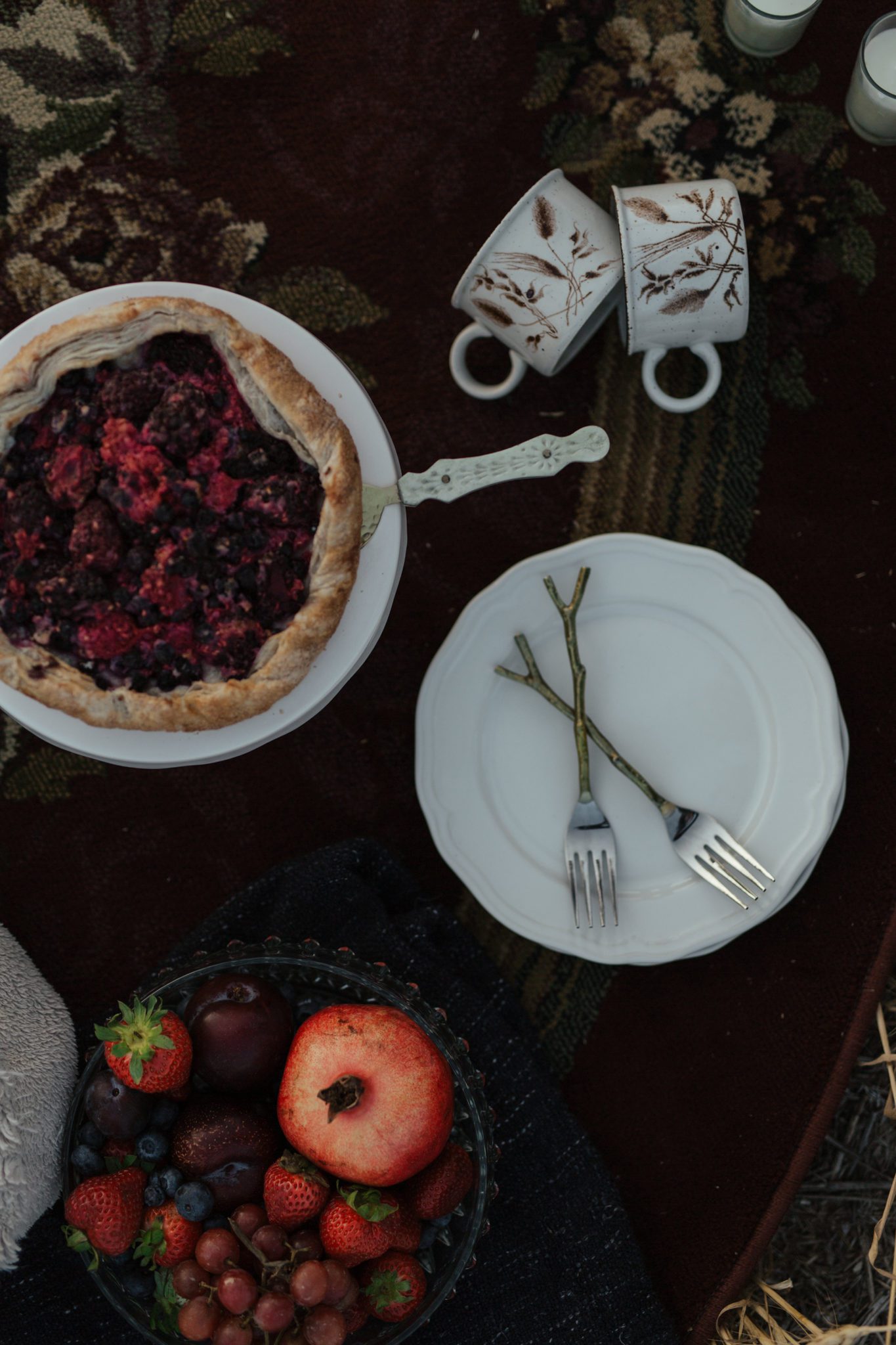 A close up detailed photo of the wedding dessert, berry galette, and vintage mugs for the couple. 