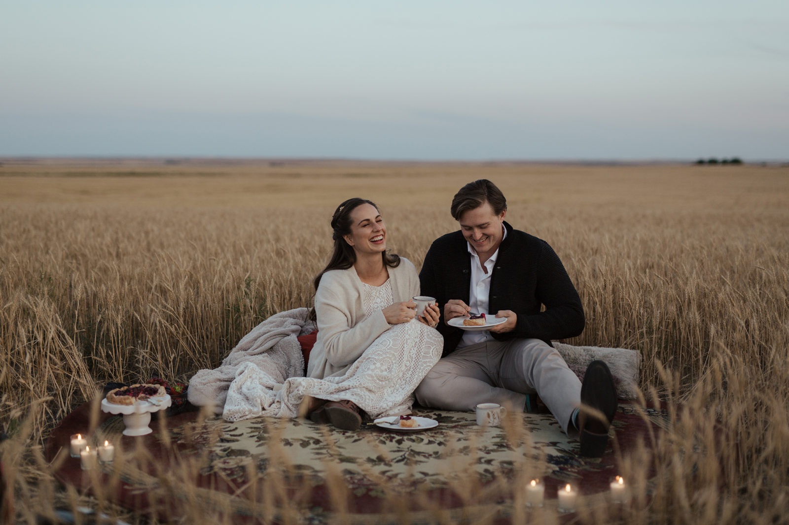 A small farmyard picnic in a rural countryside field, the bride and groom enjoy their wedding dessert and warm drinks in vintage mugs, fall vow renewal inspiration. 
