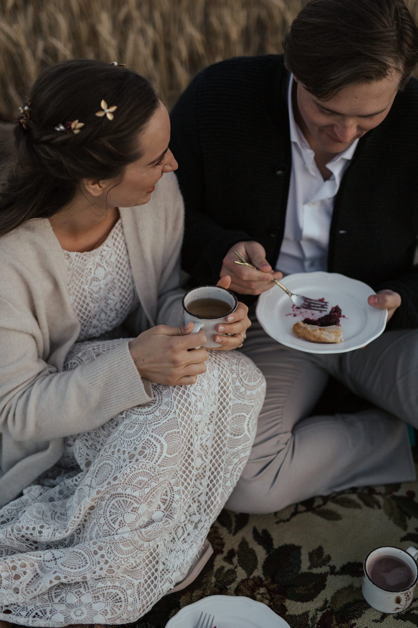 A small farmyard picnic in a rural countryside field, the bride and groom enjoy warm drinks in vintage mugs and berry galette for dessert, fall vow renewal inspiration. 