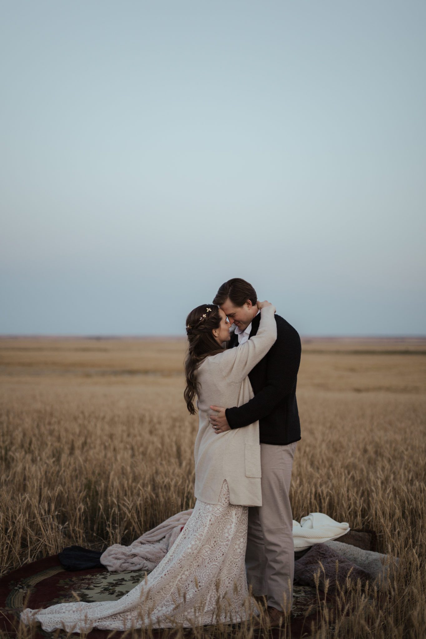 The newlyweds embrace each other while sharing a first dance in an open field, fall vow renewal inspiration. 