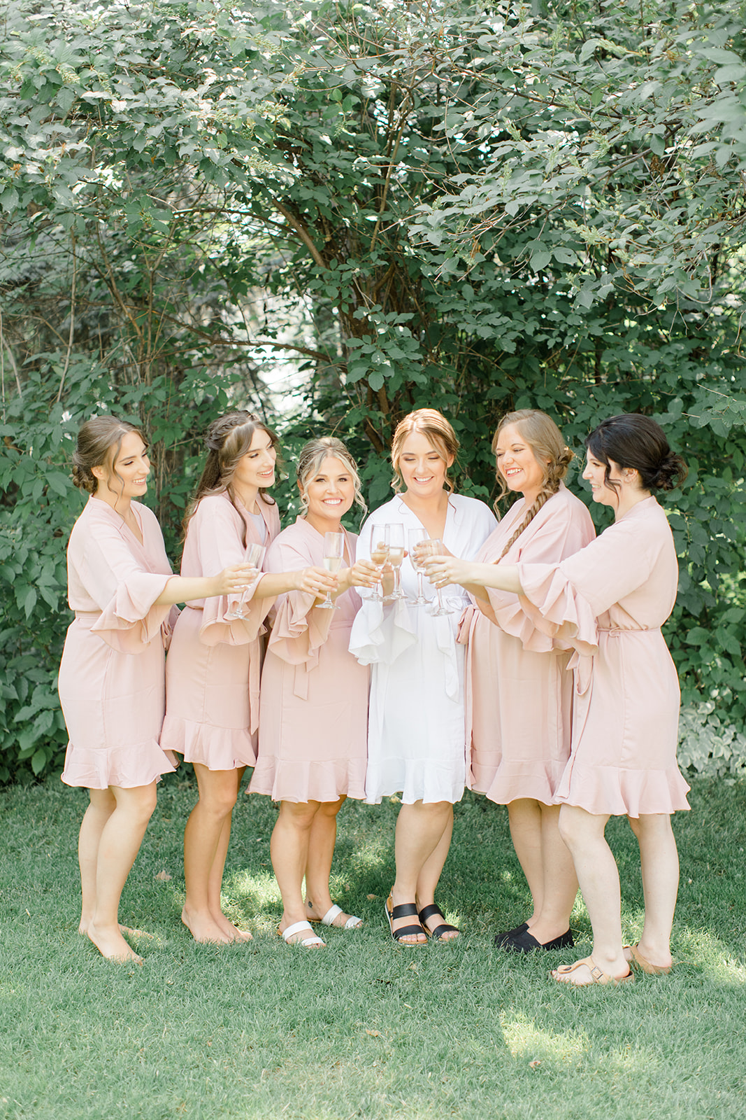 Bridal party champagne toast at outdoor wedding, bridal robes