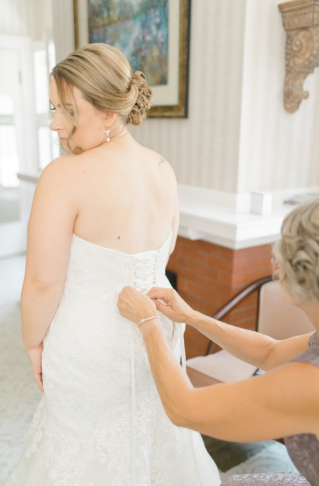 Bride getting ready for wedding day, lacing up bridal gown