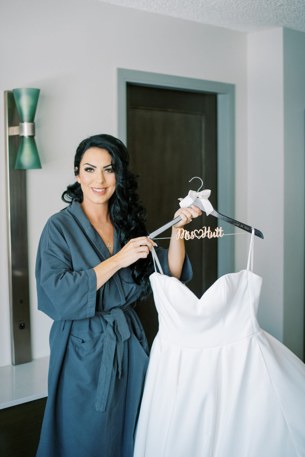 Bridge getting ready in navy bridal gown and custom wedding gown hanger