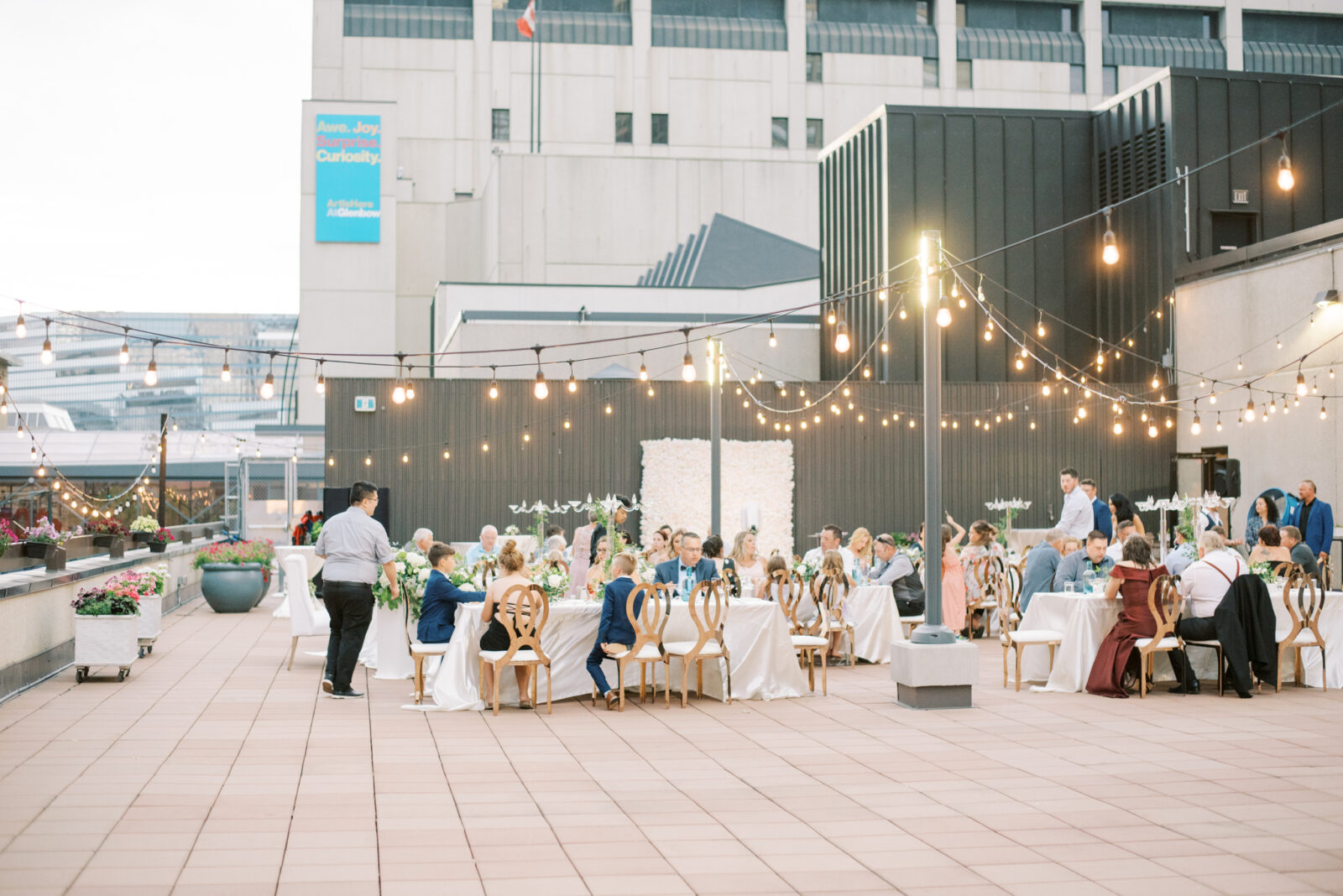 outdoor wedding reception with glass chandelier, gold, and greenery with string lights