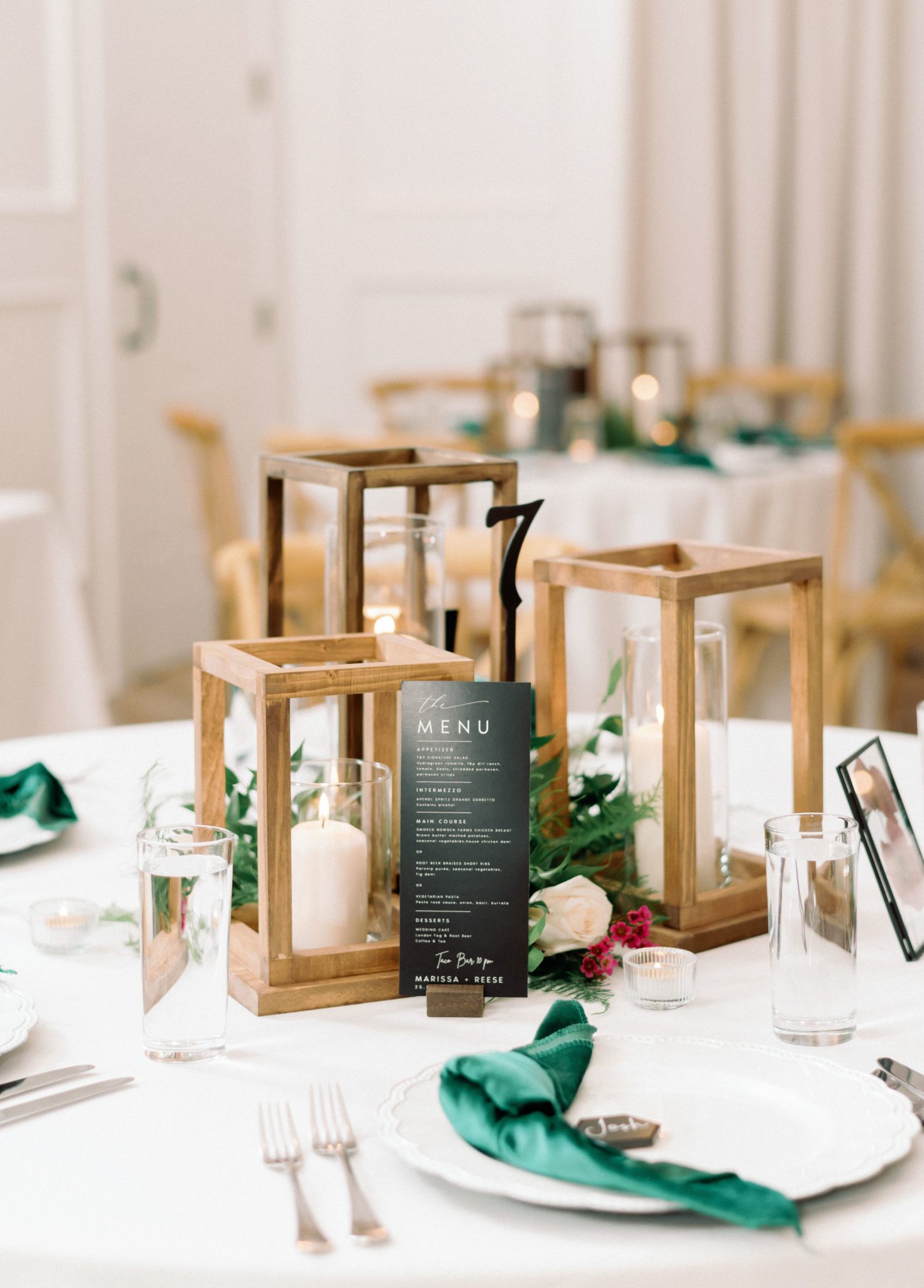 candlelit wedding centrepieces, wedding table with wood lantern centerpieces and a black table menu, green velvet napkins