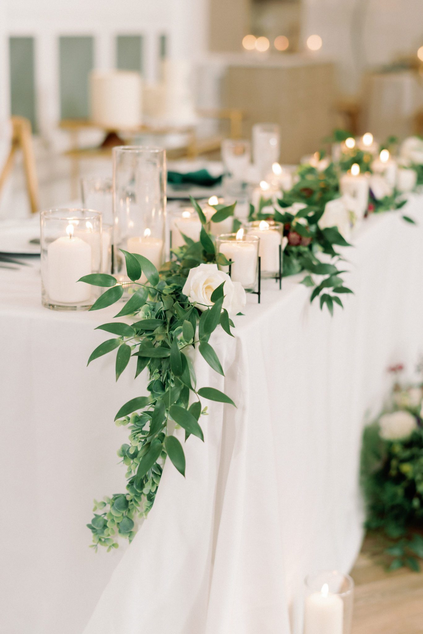 wedding sweetheart table with candles and greenery 