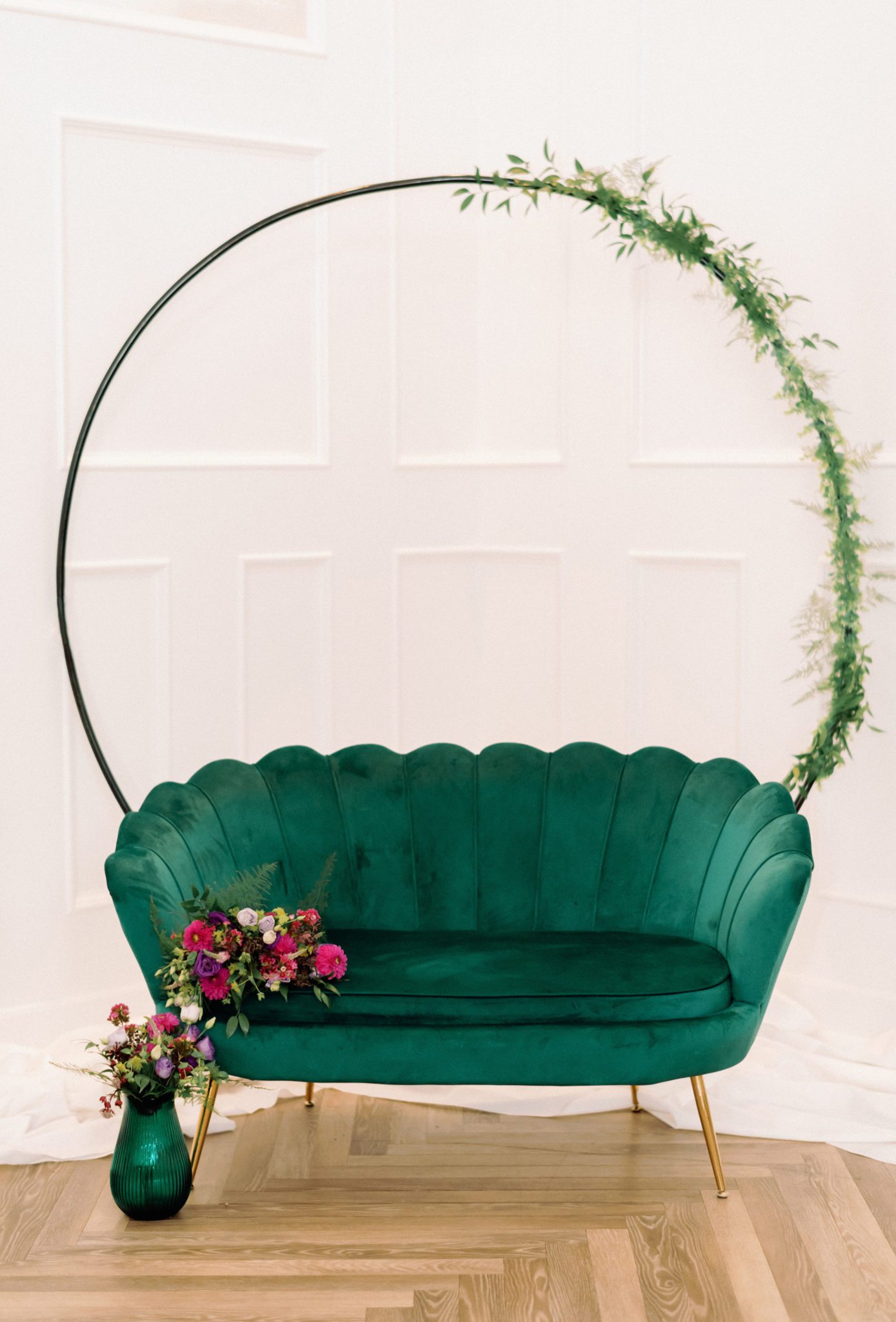 wedding photo backdrop, circle arch with greenery and emerald green couch, Jewel toned Wedding Colour palette