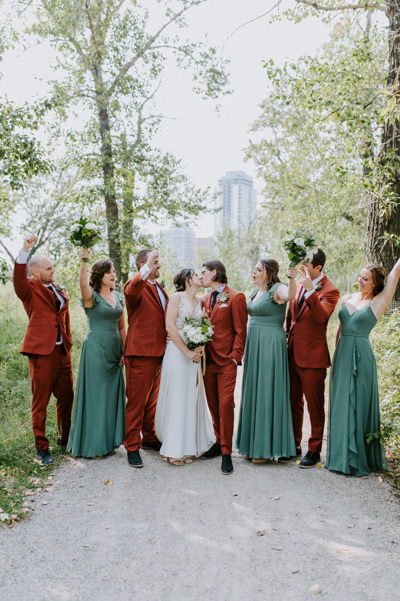 outdoor wedding party portraits, rust and terracotta suits and sage bridesmaids dresses for this fall wedding attire