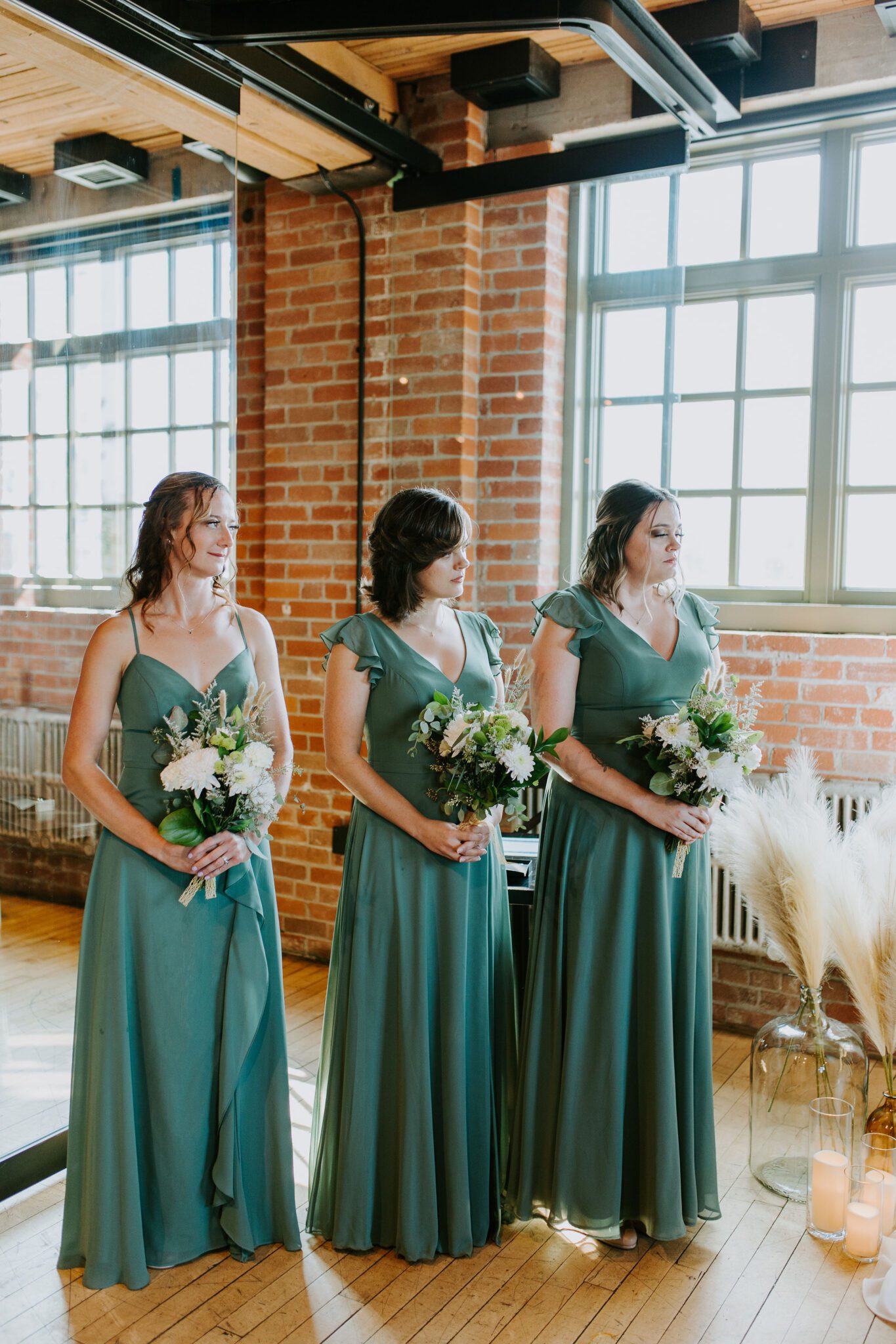 Bridesmaid's in sage dresses, white and green wedding bouquets