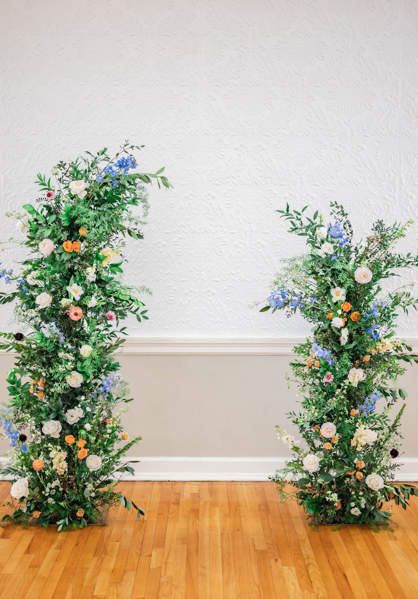Stunning column floral arch with lush greenery by Sweet Bloom as a focal point of the an indoor ceremony, whimsical and romantic pastel spring wedding inspiration