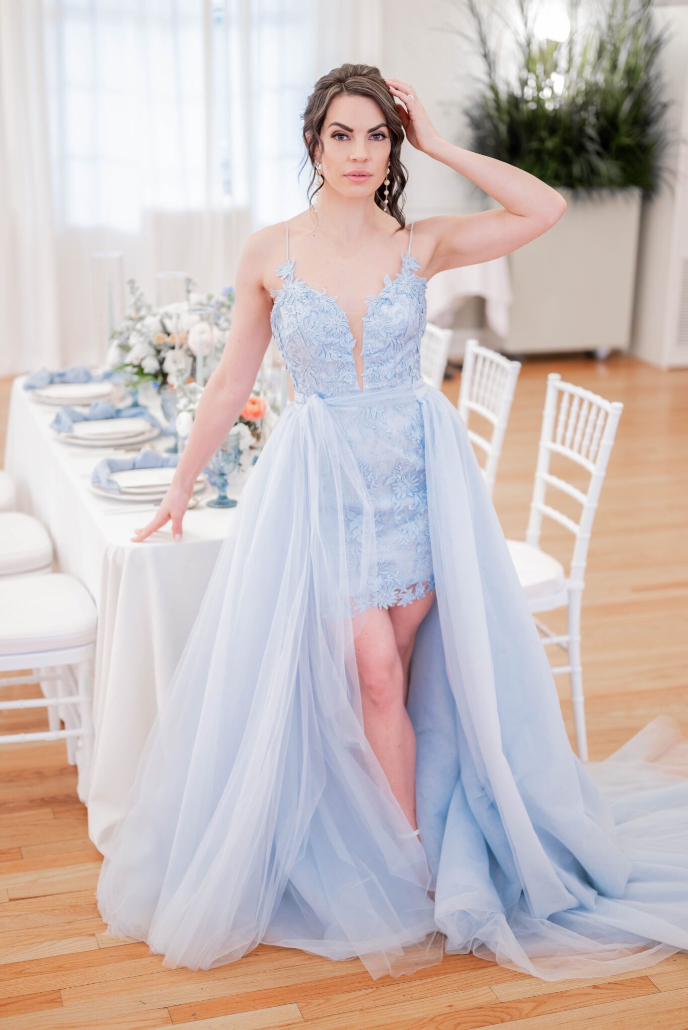 Feminine baby blue high/low wedding gown, coloured wedding dress inspiration for spring wedding, bridal portrait by guest table styled with vintage blue glassware